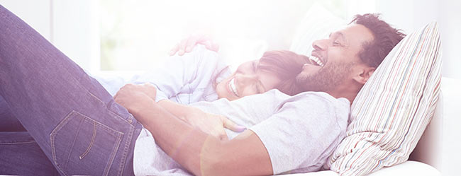 Frau liegt Mann im Bett im Arm und beide sind glücklich nach ihrer Partnersuche ab 40