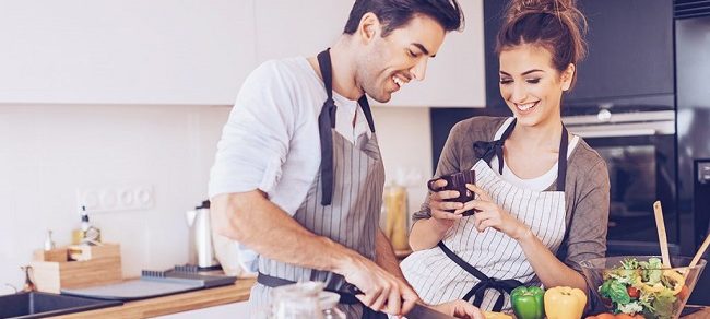 Frau macht Ihrem Mann die passenden Komplimente beim Kochen