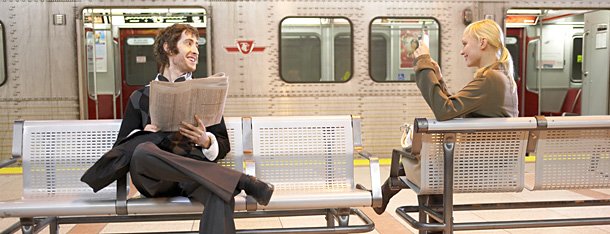 Mann und Frau beim Warten auf der U-Bahn und kommen über Flirtspruch ins Gespräch