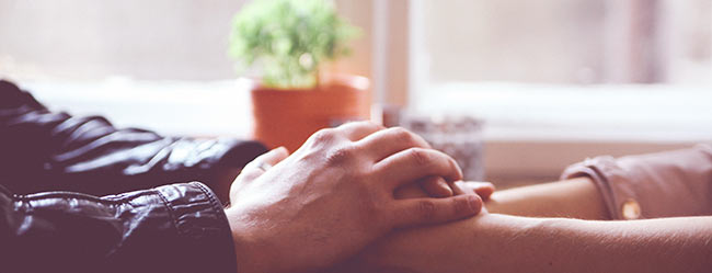 Freundschaft mit dem Ex symbolisch durch zwei aufeinandergelegte Hände von Mann und Frau