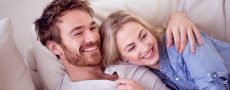 Partnervermittlung hat Frau und Mann, die glücklich auf Couch kuscheln, zusammengebracht