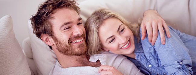 Partnervermittlung hat Frau und Mann, die glücklich auf Couch kuscheln, zusammengebracht