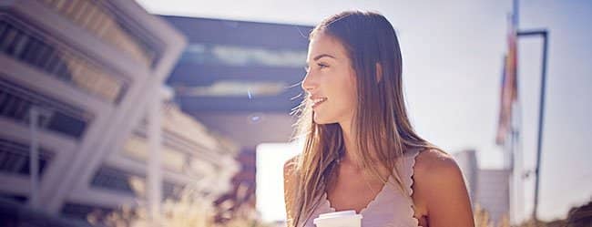 Unnahbare Frau mit Kaffeebecher in der Hand
