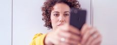Frau ist schaut gefühlskalt auf ihr HandyFrau ist schaut gefühlskalt auf ihr Handy