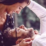 Mann liegt mit Kopf auf Schoß seiner Partnerin und genießt die Vorteile Ihrer Beziehung