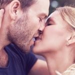 Mann mit Bart küsst Frau mit rotem Lippenstift richtig