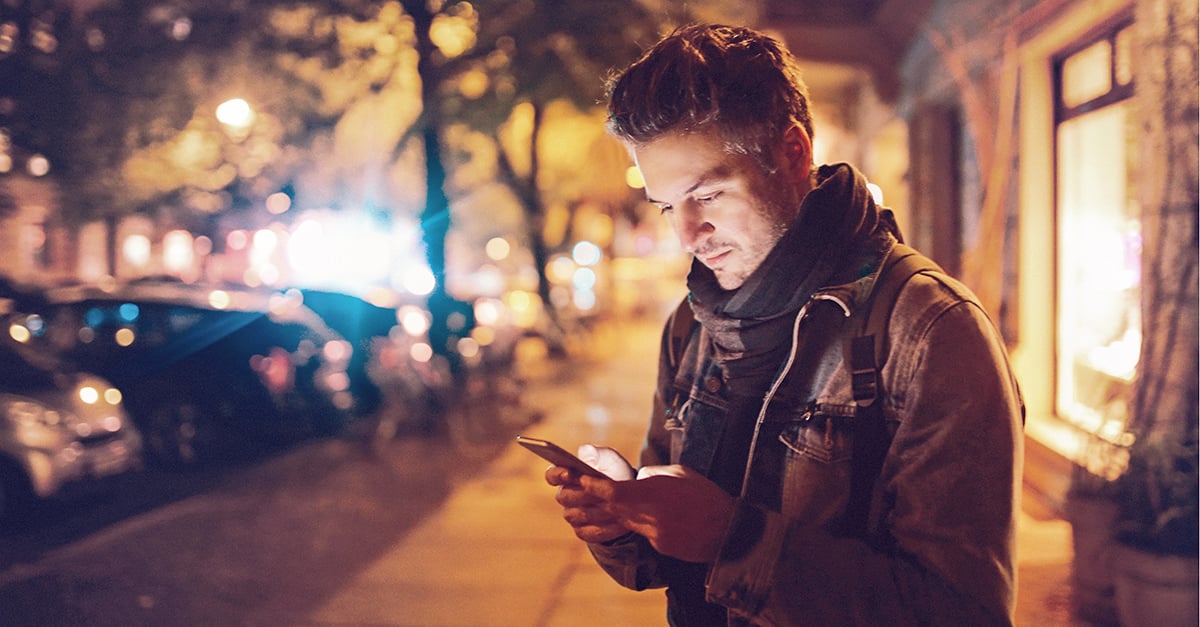 Mann steht mit Handy an der Straße, die Ex meldet sich wieder