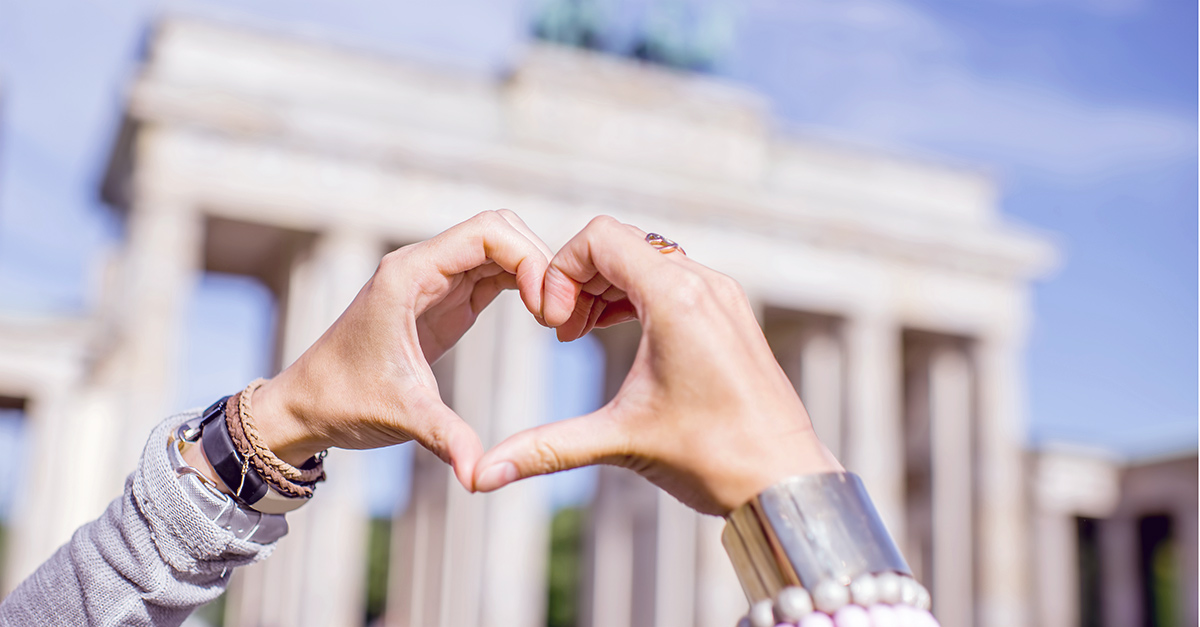 Liebes Atlas 2017 symbolisiert durch ein mit der Hand geformtes Herz vor dem Brandenburger Tor