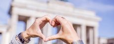 Liebes Atlas 2017 symbolisiert durch ein mit der Hand geformtes Herz vor dem Brandenburger Tor
