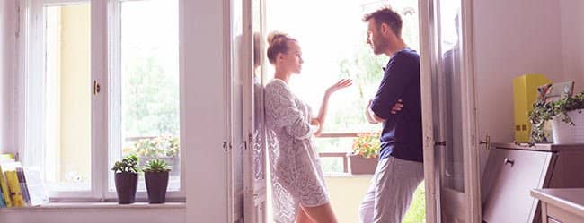 Mann und Frau stehen in Tür und wollen Eifersucht bekämpfen