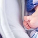 Ausschnitt Babyfuss im Kinderwagen als Zeichen für Torschlusspanik