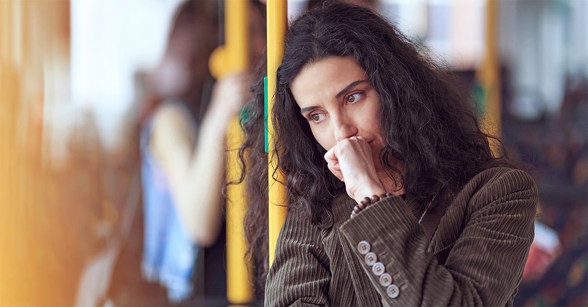 Frau steht in der Bahn und hat Schuldgefühle nach der Trennung