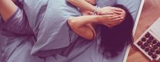 Frau mit zusammengeschlagenen Händen vor Gesicht im Bett und versucht Ex zu vergessen