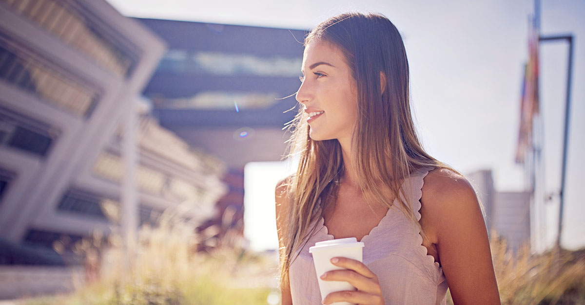 Unnahbare Frau mit Kaffeebecher in der Hand