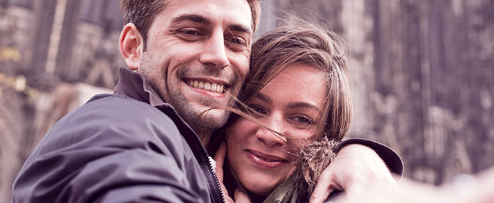 Mann und Frau lächen in Kamera - als Symbol für Beziehungsstatus