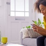 Eine Junge Frau sitzt am Smartphone