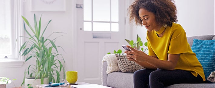 Eine Junge Frau sitzt am Smartphone